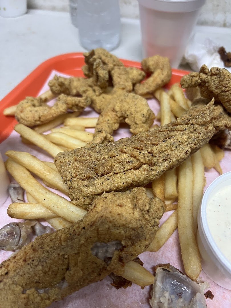 Fried chicken pieces on a simple takeout tray.